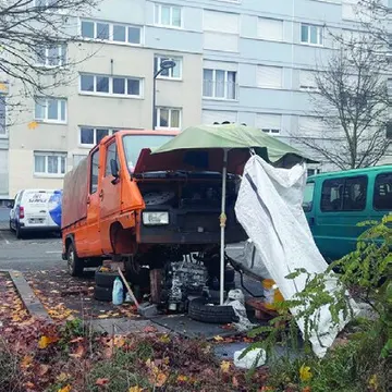 Camionnettes démontées sur un parking de résidence